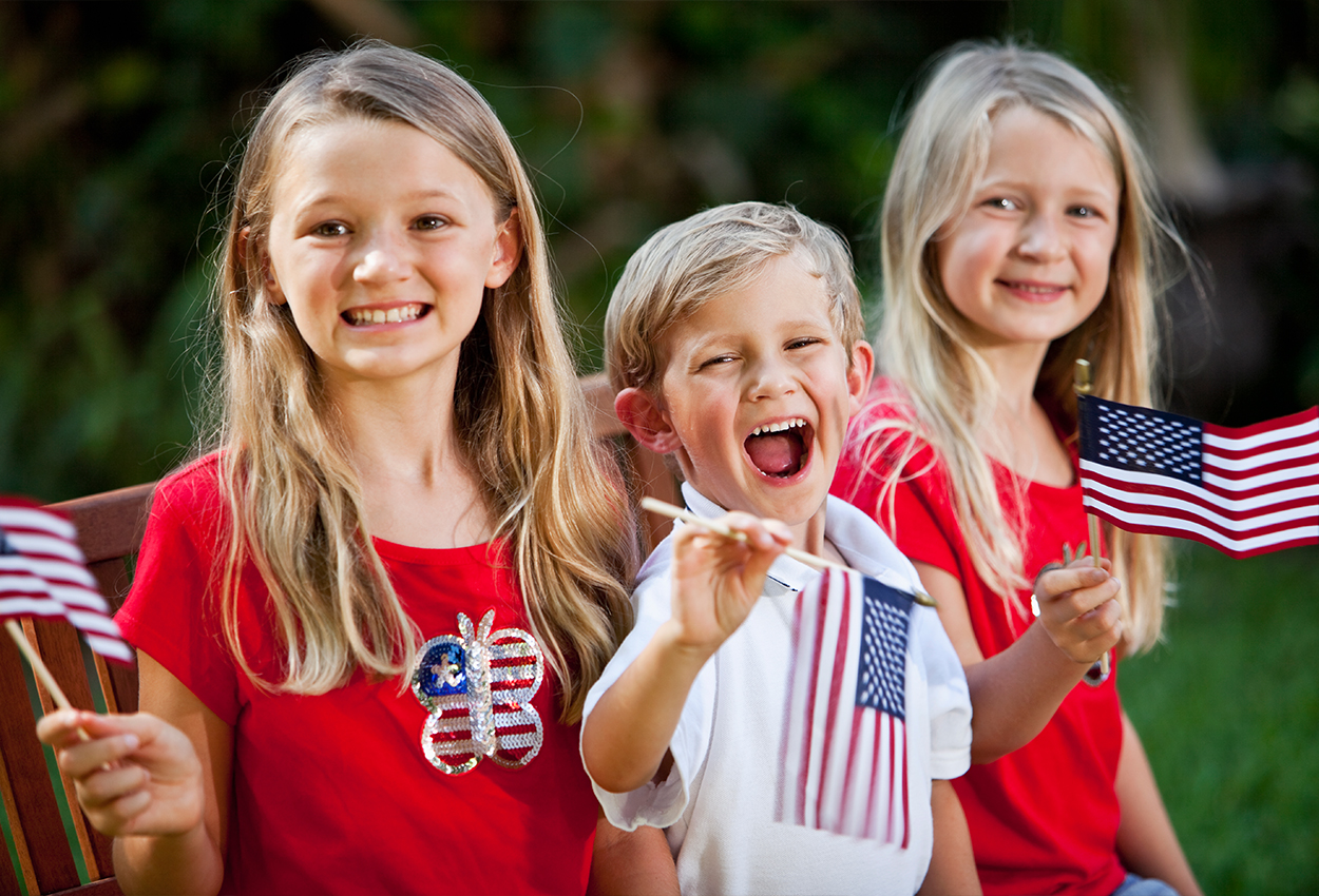 Three children holding american flags