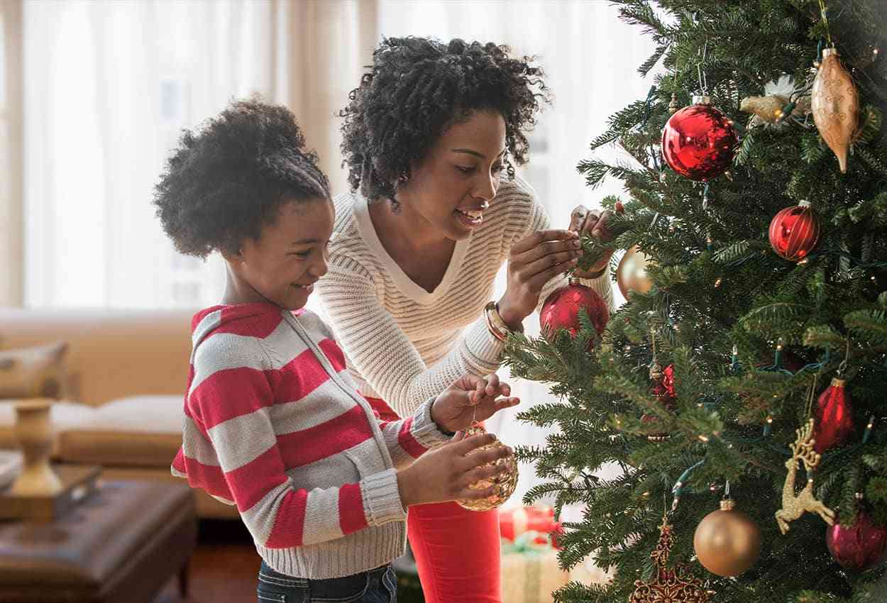 Mother and daughter decorating a Christmas tree