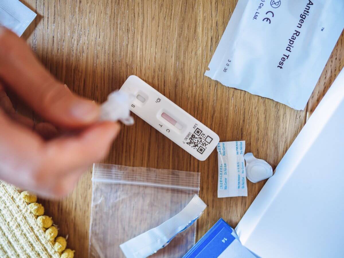 Extreme close up of a person's hands using an at-home COVID-19 test kit