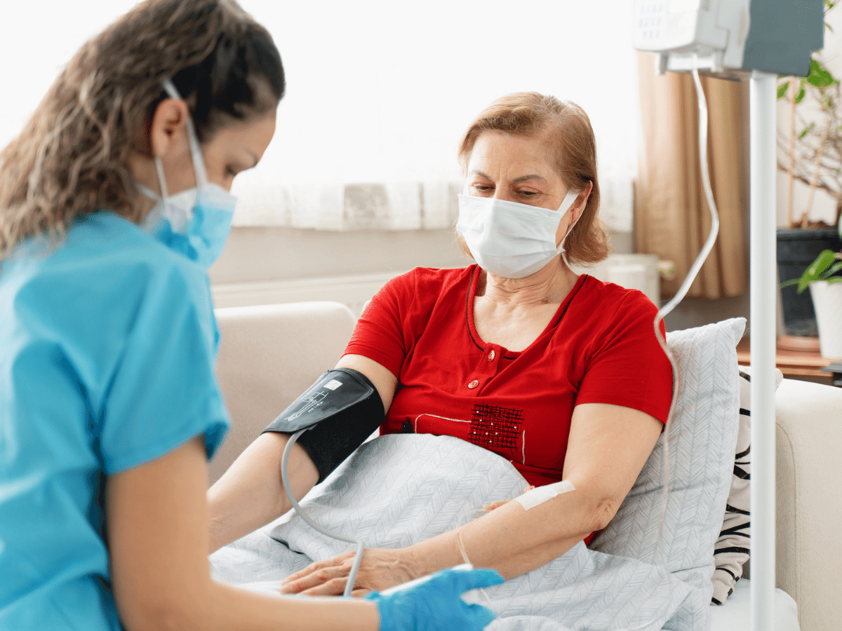 Nurse administers an IV on a female patient.