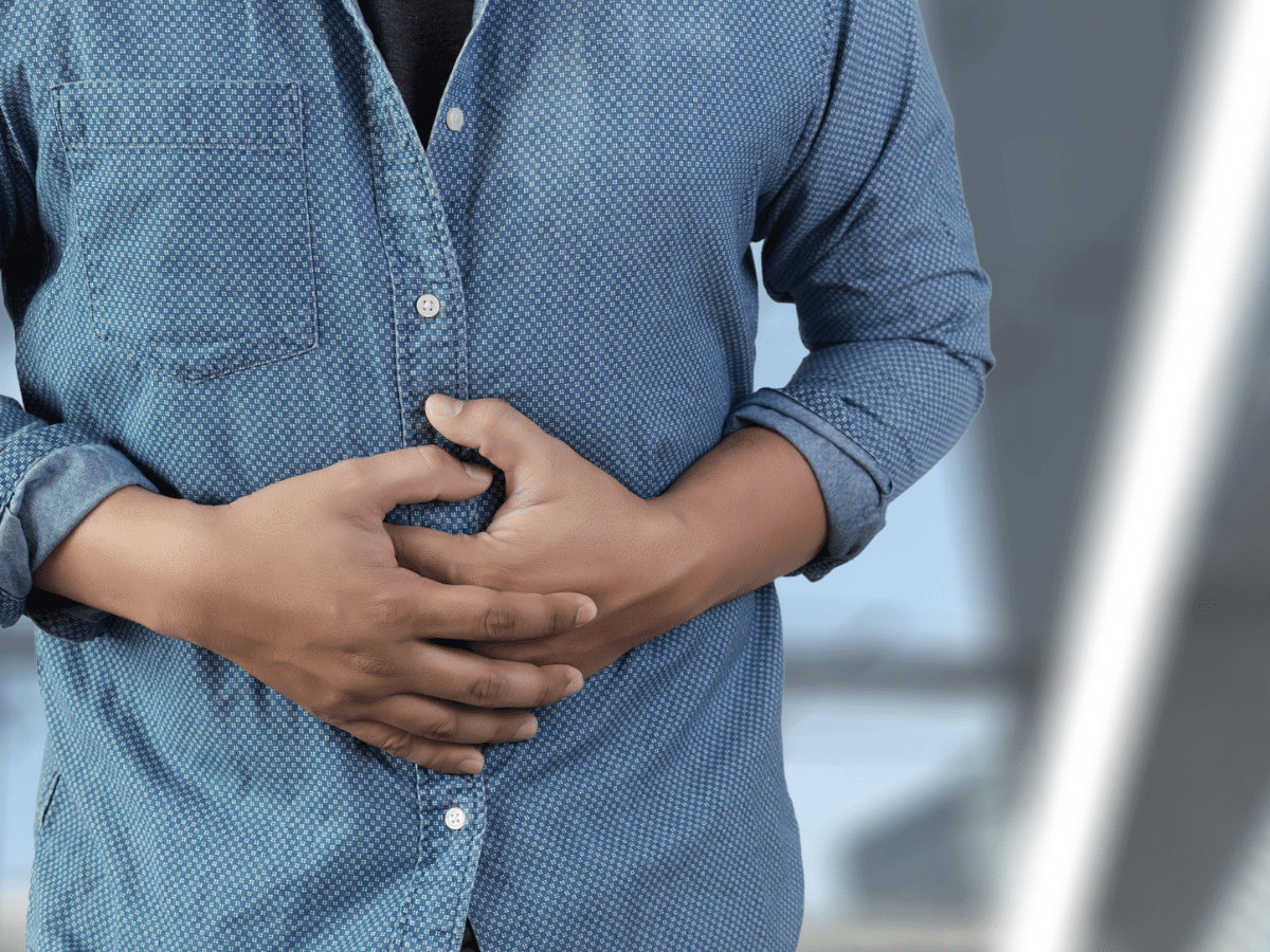 Middle-aged man holding his stomach in pain.