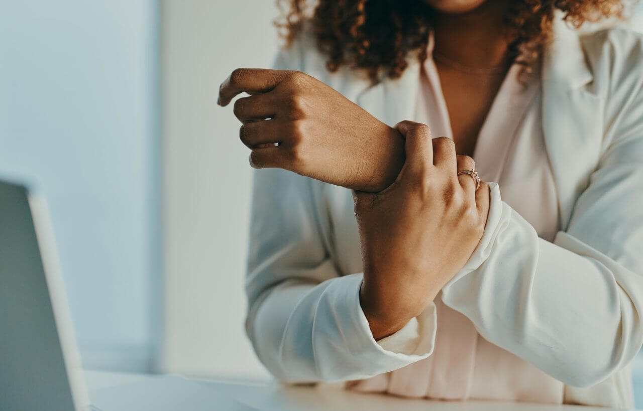 Close up of young woman holding her wrist in pain